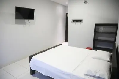a bedroom with a bed and a flat screen tv at Hospedaje Aquel Almendro in Santa Fe de Antioquia