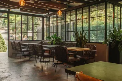 a restaurant with tables and chairs and windows at Cafe Hotel Medellín in Medellín