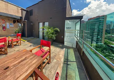a patio with a wooden table and chairs on a building at Cafe Hotel Medellín in Medellín