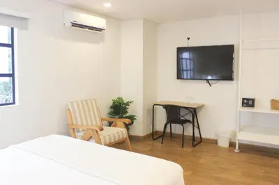a bedroom with a tv and a chair and a table at 574 Hotel in Medellín