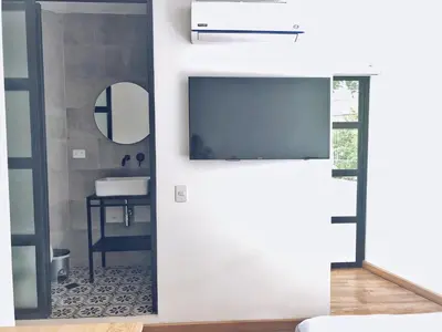 a bathroom with a sliding door with a tv on the wall at 574 Hotel in Medellín