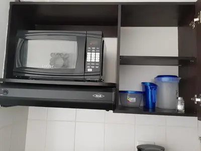 a black microwave oven in a kitchen at Apartasuites Medellin Los Molinos in Medellín