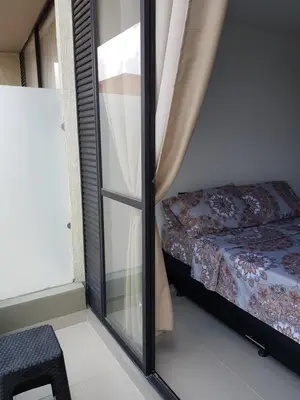 a bedroom with a glass window next to a bed at Apartasuites Medellin Los Molinos in Medellín