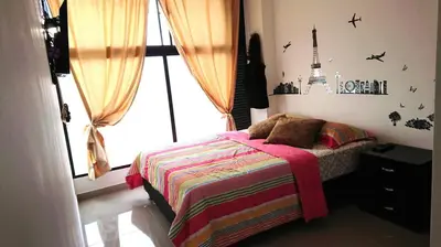 a small bedroom with a bed and a window at Apartasuites Medellin Los Molinos in Medellín