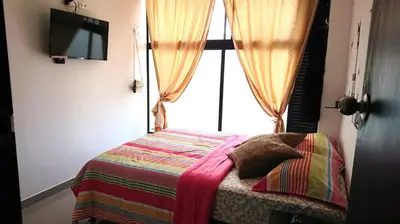 a bedroom with a bed with a window at Apartasuites Medellin Los Molinos in Medellín