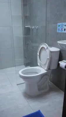 a bathroom with a toilet and a glass shower at Vivienda turística mi sueño Jardín in Jardin