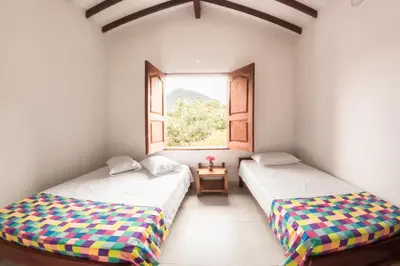 two beds in a room with a window at Vivienda turística mi sueño Jardín in Jardin
