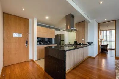a kitchen with a black counter top and wooden cabinets at Estelar La Torre Suites in Medellín