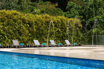 a group of chairs sitting next to a swimming pool at Estelar La Torre Suites in Medellín