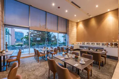 a restaurant with tables and chairs and a large window at Estelar La Torre Suites in Medellín