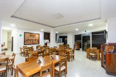 a restaurant with wooden tables and wooden chairs at Hotel Bicentenario Rionegro in Rionegro