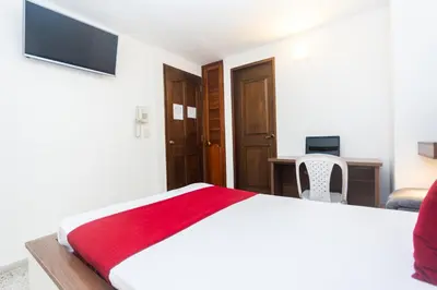 a bedroom with a bed and a desk with a computer at Hotel Bicentenario Rionegro in Rionegro