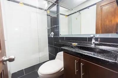 a bathroom with a toilet and a sink and a mirror at Hotel Bicentenario Rionegro in Rionegro