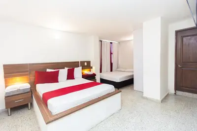 a bedroom with a large bed with red pillows at Hotel Bicentenario Rionegro in Rionegro