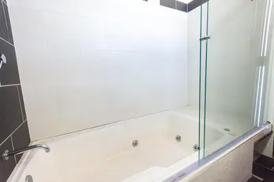 a white bath tub with a glass shower door at Hotel Bicentenario Rionegro in Rionegro