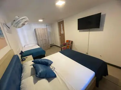 a hospital room with two beds and a tv at Air Guest House - con Desayuno & Jacuzzi Social in Medellín