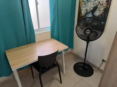 a desk with a fan next to a table with a chair at Air Guest House - con Desayuno & Jacuzzi Social in Medellín