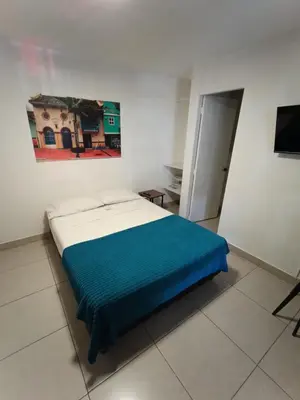 a bedroom with a bed with a blue blanket at Air Guest House - con Desayuno & Jacuzzi Social in Medellín
