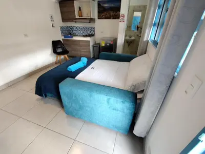 a room with a bed and two blue chairs at Air Guest House - con Desayuno & Jacuzzi Social in Medellín