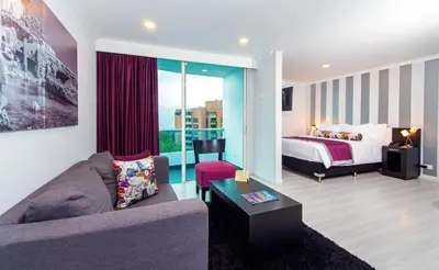 a living room with a bed and a couch and a bedroom at The Morgana Poblado Suites Hotel in Medellín