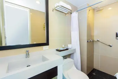 a bathroom with a sink and a toilet and a mirror at The Morgana Poblado Suites Hotel in Medellín