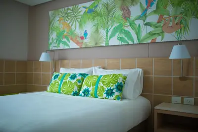 a bedroom with a bed with a painting on the wall at Mia Hotel Choco in Quibdó