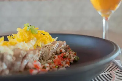 a plate of food on a table with a glass of wine at Mia Hotel Choco in Quibdó