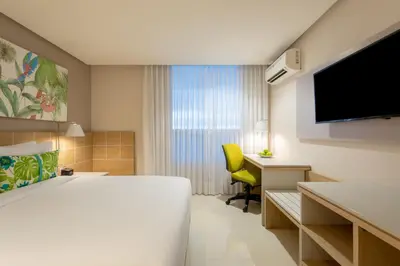 a hotel room with a bed and a desk and a television at Mia Hotel Choco in Quibdó