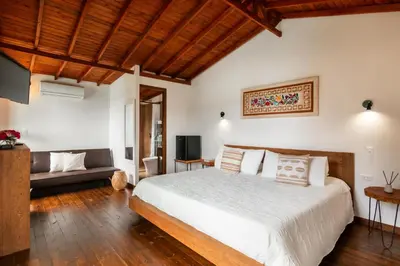 a bedroom with a large bed and a couch at Serendipity Hospedaje Boutique in Guatapé