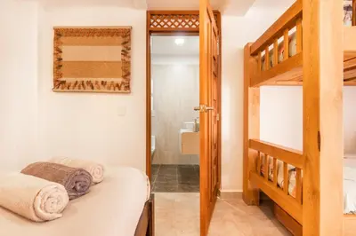 a bedroom with a bunk bed and a bathroom at Serendipity Hospedaje Boutique in Guatapé