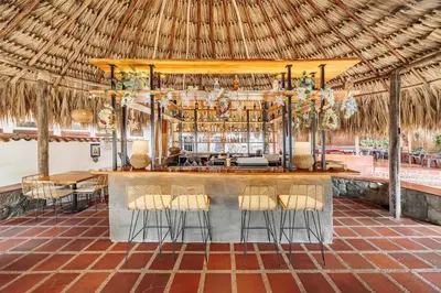 a bar in a resort with a straw roof at Hotel Quimbaya in San Jerónimo