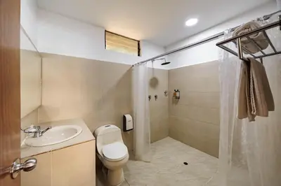 a bathroom with a toilet and a sink and a shower at Hotel Quimbaya in San Jerónimo