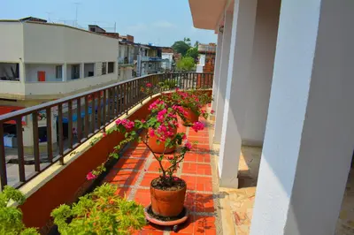 a balcony with potted plants on a building at Hotel Tayrona in Puerto Berrío