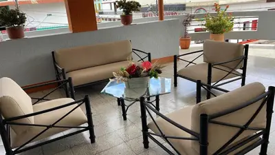a lobby with chairs and a table with flowers on it at Hotel Tayrona in Puerto Berrío