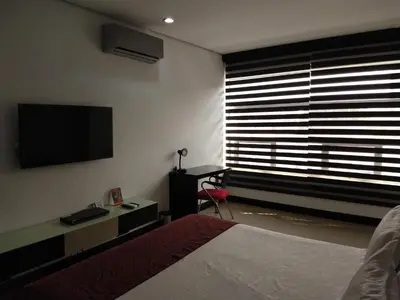 a bedroom with a bed and a television on the wall at Hotel Merlott 70 in Medellín