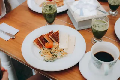 a table with a plate of food and a cup of coffee at Ángel de Santa Fe by Bernalo Hotels in Santa Fe de Antioquia