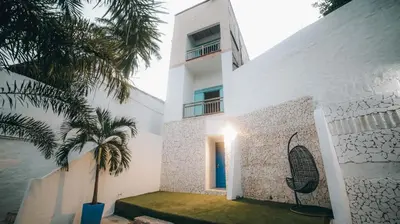 a white building with a palm tree in front of it at Ángel de Santa Fe by Bernalo Hotels in Santa Fe de Antioquia