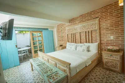 a bedroom with a bed and a brick wall at Ángel de Santa Fe by Bernalo Hotels in Santa Fe de Antioquia