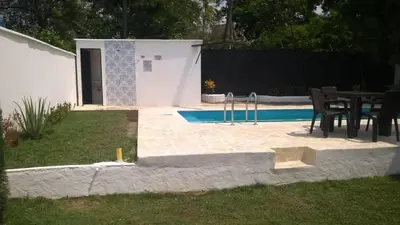 a swimming pool with a table and chairs next to it at Villas del Guali - Piscina Privada in Santa Fe de Antioquia