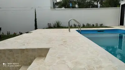a swimming pool next to a white wall and a swimming pool at Villas del Guali - Piscina Privada in Santa Fe de Antioquia