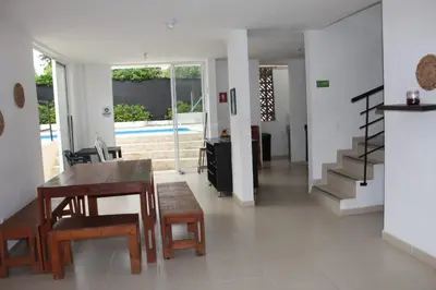 a living room with a table and chairs and a staircase at Villas del Guali - Piscina Privada in Santa Fe de Antioquia