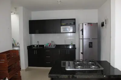 a kitchen with black cabinets and a white refrigerator at Villas del Guali - Piscina Privada in Santa Fe de Antioquia