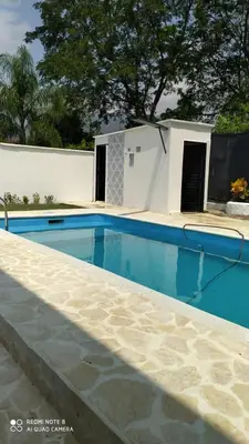 a swimming pool in front of a house with a building at Villas del Guali - Piscina Privada in Santa Fe de Antioquia