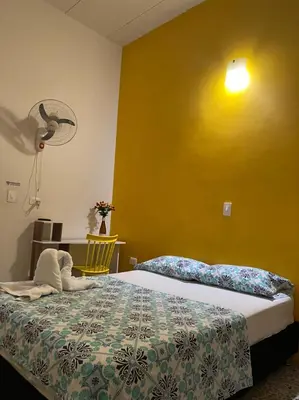 a bedroom with a bed and a yellow wall at Casa de Luna in La Dorada