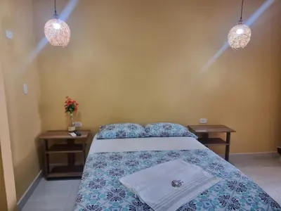 a bedroom with a bed with two tables and two towels at Casa de Luna in La Dorada