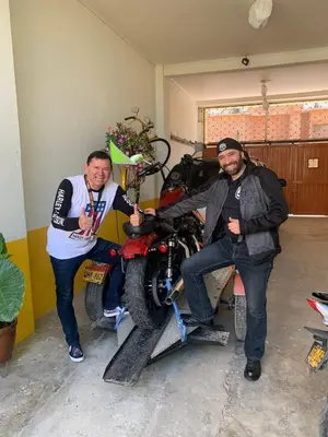 two men are posing for a picture with a motorcycle at Casa de Luna in La Dorada