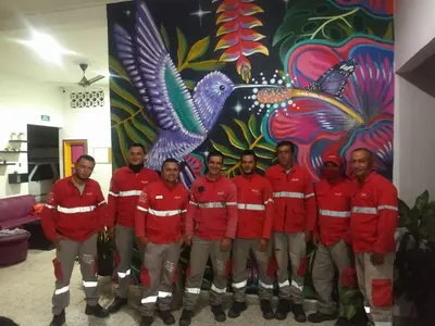 a group of men in red jackets standing in front of a mural at Casa de Luna in La Dorada