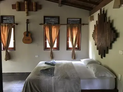 a bedroom with a bed with windows and a guitar at Ritmo del Rio in San Rafael