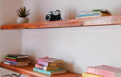 a bunch of books sitting on a wooden shelf at Buntes House-Casa Hotel Laureles-Estadio in Medellín