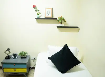 a white couch with a black pillow and a side table at Buntes House-Casa Hotel Laureles-Estadio in Medellín